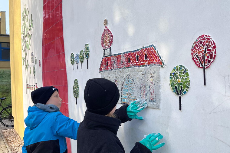 Die Kinder beim Verfugen der Mosaike